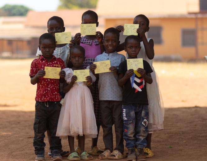 Children proudly show their vaccination cards in Yambio during the targeted campaign in Western Equatoria state.